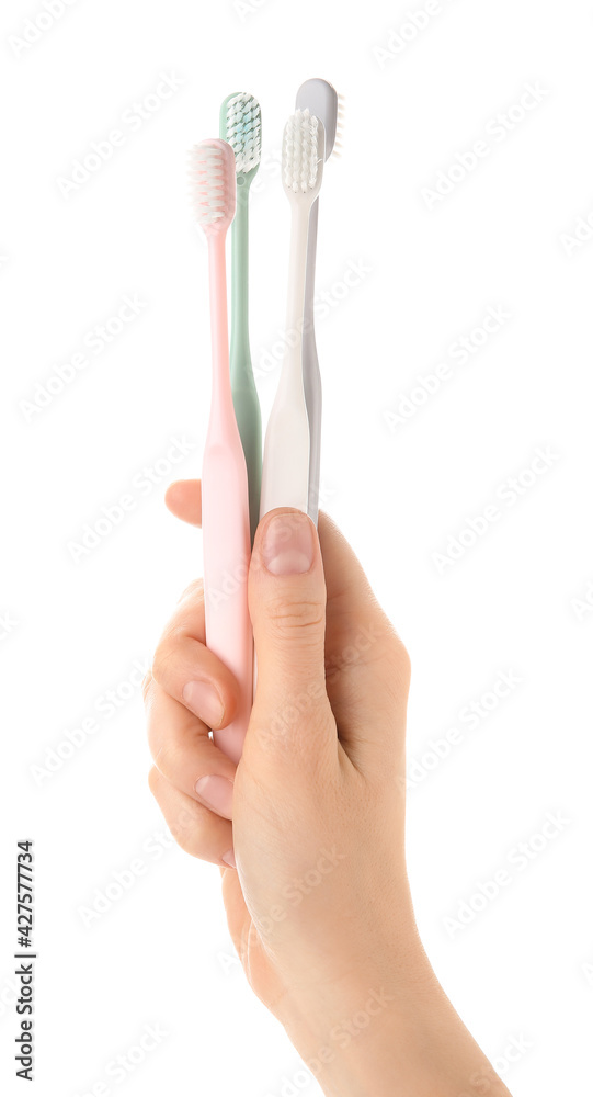 Female hand with tooth brushes on white background