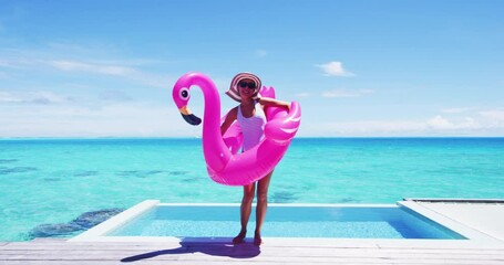 Wall Mural - Vacation travel fun. Funny woman dancing happy and cheerful and funny with flamingo swimming pool float around waist excited of tropical hotel holiday getaway