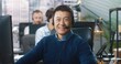 © VAKSMANV - Close up portrait of Asian cheerful handsome male call center operator sitting at table at company office in headset looking at camera and smiling. Joyful man employee at workplace, work concept