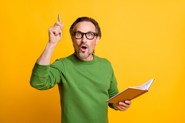 Poster - Photo of genius clever writer hold copybook pen shocked open mouth wear glasses green pullover isolated yellow color background