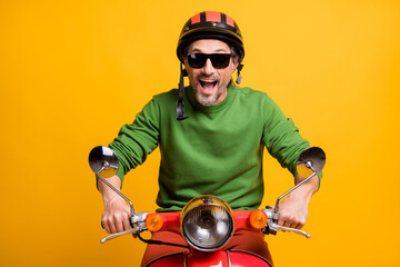 Poster - Photo of amazed funny guy ride moped wear helmet spectacles green pullover isolated yellow color background