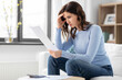© Syda Productions - accounting, taxes and finances concept - stressed young woman with papers and calculator at home