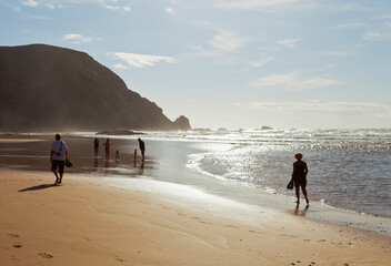 Wall Mural - Portugal. People walk barefoot along the sandy, sun-drenched Praia da Castelejo beach in the Algarve on the Atlantic coast. Picturesque sunny seascape. Summer travel and family recreation