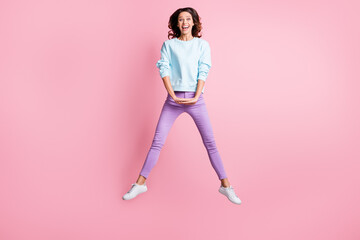 Wall Mural - Full length body size photo of jumping brunette girl laughing cheerfully isolated on pastel pink color background