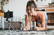 © simona - Healthy lifestyle people fitness workout content creator - pretty happy woman record exercises with her phone - online personal trainer class - modern gym at home and pretty woman in plank position