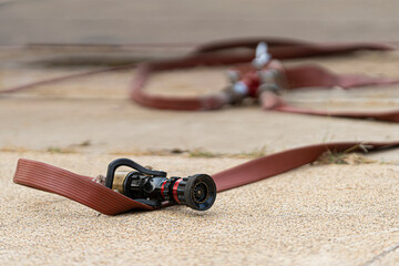 Poster - Red Fire hose And high pressure water jets nozzle on the floor
