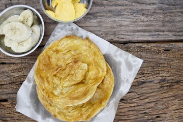 Wall Mural - Indian naan bread homemade with butter and banana fruit on paper background India food