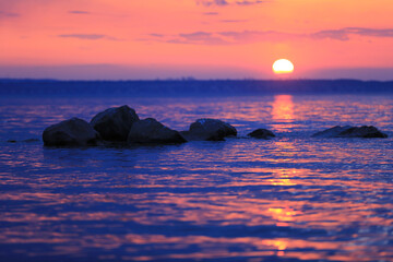 Canvas Print - stones in lake water on sunset