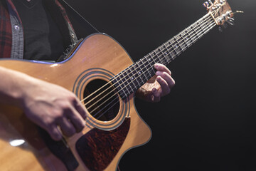 Wall Mural - Guitarist playing acoustic guitar in the dark.