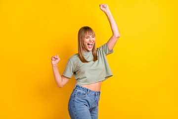 Wall Mural - Portrait of attractive glad cheerful girl having fun moving clubbing isolated over bright yellow color background