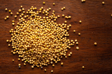 Wall Mural - Macro close-up of Organic Mustard seed (Sinapis alba) on wooden top background. Pile of Indian Aromatic Spice. Top view