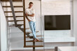 © Yaroslav Astakhov - Relaxing happy caucasian man on the minimalistic stairs in modern light apartment