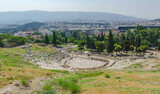 Fototapeta  - Ancient Dionysus theater under the ruins of Acropolis, with view over the city of Athens, Greece, in summer sunny day