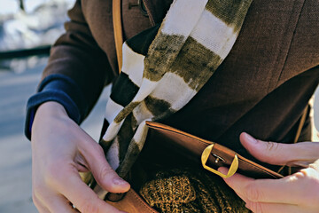 beautiful female hands open leather light brown handbag. selective focus photo