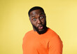 Black man with surprised and amazed expression. yellow background