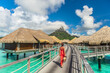 Tahiti luxury hotel honeymoon travel vacation tourist woman walking at luxury resort in overwater bungalows villas. View of Mount Otemanu, Bora Bora, French Polynesia