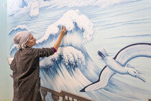 Mature Woman Artist Draws A Mural On A Marine Theme