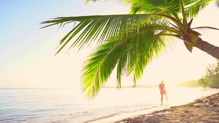 Wall Mural - Sunrise over tropical island beach and palm trees. Punta Cana, Dominican Republic. Running woman on the sand.