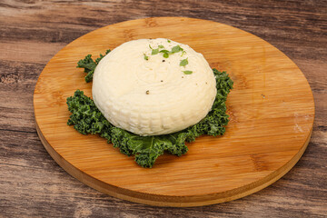 Caucasian suluguni round cheese piece