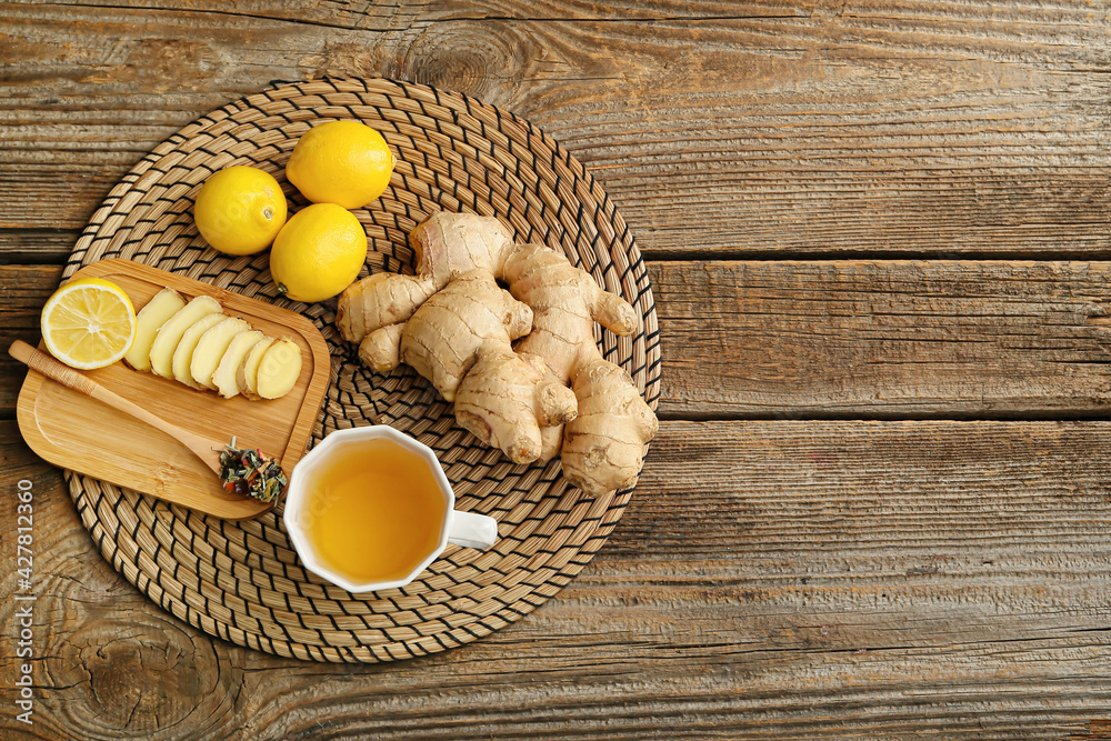 Cup of tea with ginger and lemon on wooden background