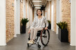 © Drobot Dean - White young woman smiling while sitting in wheelchair at office