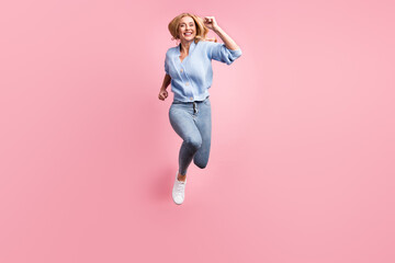 Poster - Full size photo of young happy positive good mood girl running fast in air wear blue cardigan isolated on pink color background