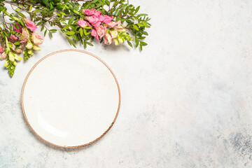 Wall Mural - Table setting with white plate, cutlery and flowers.