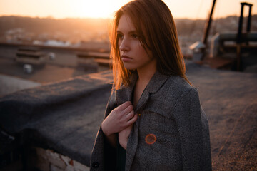 Beautiful woman standing on rooftop and looking aside