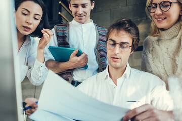 Wall Mural - Group of millenials working together in loft office