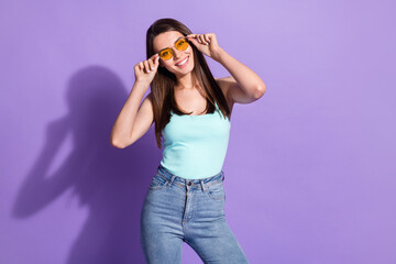 Wall Mural - Photo of charming lovely young woman hold wear glasses jeans tank-top isolated on purple color background