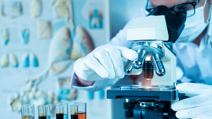 Doctor looking in microscope while working on medical research in science laboratory