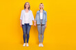© deagreez - Full length body size photo of granddaughter and granny wearing casual clothes holding hands isolated vibrant yellow color background