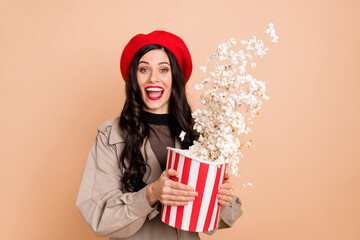 Canvas Print - Photo portrait of excited girl throwing popcorn from big bag isolated on pastel beige colored background