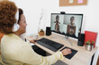 © DisobeyArt - African woman having video call with her colleagues using computer app - Soft focus on right hand