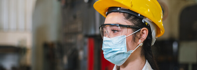 Asian woman engineering wear protection face mask and safety helmet in factory Industrial. new normal work during covid-19. crop image baner.