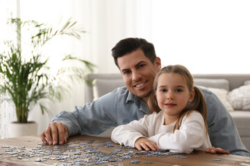 Poster - Man and his little daughter playing with puzzles at home