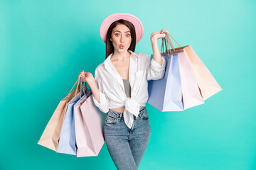 Sticker - Photo of charming sweet young lady wear white shirt cap holding shopping bags sending kiss isolated turquoise color background