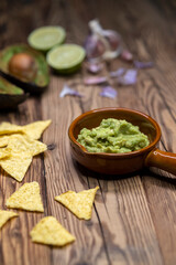 Wall Mural - avocado dip flavored with garlic, chili, pepper, and lime juice with corn nachos