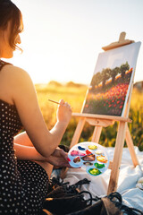 Young girl paints on cavans outdoor