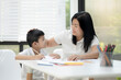 © aedkafl - Mother and son doing homework at home, Mother is teaching son to draw pictures, Children homework. Young boy doing homework on the terrace at home. Happy mood. Back to school concept.