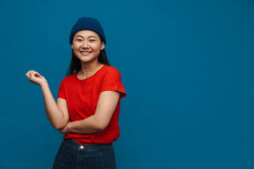 Asian teen girl in hat smiling and looking at camera