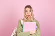 © Анастасия Каргаполов - Pretty european woman in casual sweater on pink background with notebooks shocked look to camera with open mouth, education high school concept