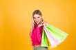 © Анастасия Каргаполов - Pretty european woman in pink  blouse on yellow background holding shopping bags shocked amazed excited isolated copy space