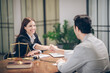 © iStocker - female lawyer shakes hands with a male businessman at her desk