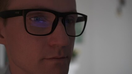 The programmer writes the program code. Reflection of the program code in glasses.