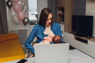 Wall Mural - Beautiful young mother working with laptop computer and breastfeeding, holding and nursing her newborn baby at home. Mom - business woman feeding newborn.