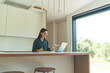 © Epic_pic - Side view of business woman working from home with laptop and notebook