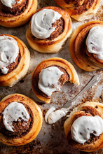 Baked Cinnamon Rolls With Frosting On A Baking Tray
