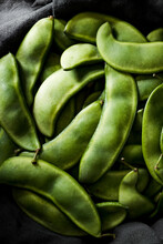 Lima Beans Pods Sitting In A Dark Grey Linen.