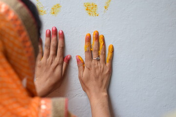 The beautiful hands making impression with yellow colour on the wall, this is the way of worship the godess